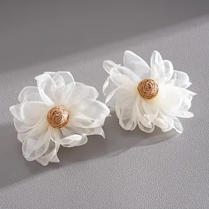 Close-up detail of white chiffon mesh petals and woven raffia center for handmade floral earrings