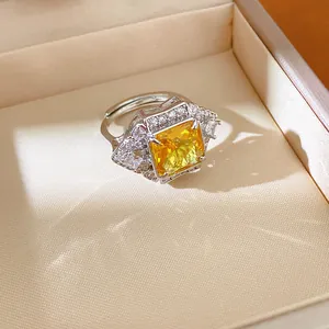 Detailed macro view of a silver-toned ring with a large yellow square-cut stone.