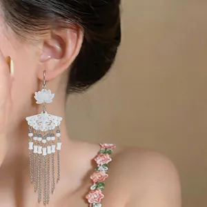 Close-up detail of elegant Neo-Chinese lotus fan earrings featuring long silver tassels.