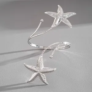 Macro view of textured silver starfish open arm cuff showing intricate metallic details