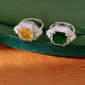 Detailed view of luxury geometric square rings featuring yellow and green zircon stones