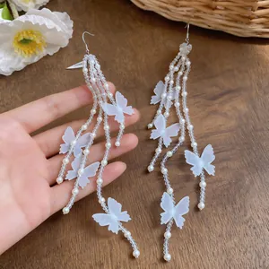 Eleganti orecchini lunghi a nappa con delicate farfalle in chiffon bianco e perle finte.