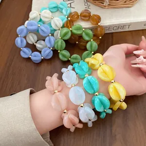 Macro view of colorful acrylic layered bead bracelets on a female wrist for vacation