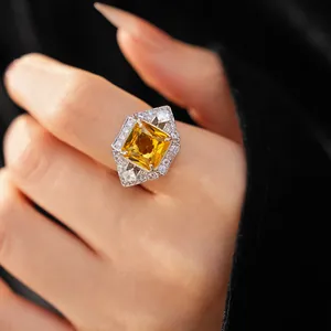 Detailed macro view of a vintage style geometric square yellow zircon ring worn on a finger