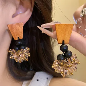 Détail de boucles d'oreilles pendantes en bois de style ethnique avec perles