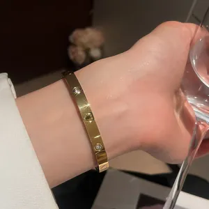 Close-up of a gold-plated heart bangle with sparkling zircons and heart engraving