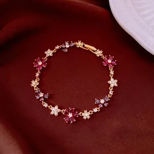 Gold-plated bracelet featuring zircon flowers and crosses with a secure clasp closure