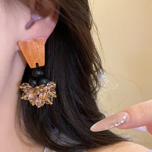 Gros plan de boucles d'oreilles ethniques avec bois et glands en perles transparentes