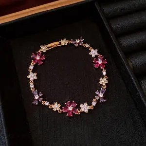Elegant gold-plated bracelet with vibrant cubic zirconia flowers and cross motifs.