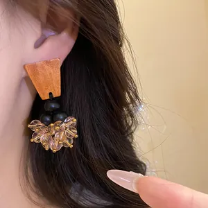Gros plan de boucles d'oreilles ethniques en bois avec glands perlés et aiguilles