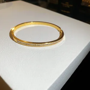 Detailed view of an elegant gold-plated bangle inlaid with sparkling cubic zirconia stones