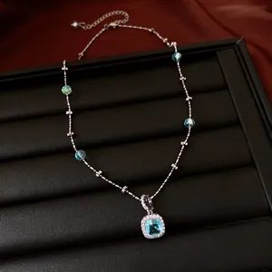 Elegant silver-toned necklace with square blue zircon pendant and crystal beads.
