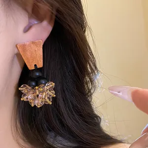 Vue détaillée de boucles d'oreilles vintage avec base en bois et glands en cristal