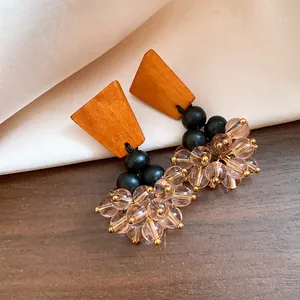 Vue détaillée de boucles d'oreilles ethniques avec clous en bois et perles roses