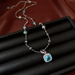 Detailed close-up of a luxury square blue gemstone pendant necklace on a jewelry display