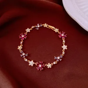 Elegant gold-plated bracelet featuring colorful cubic zirconia floral and cross charms