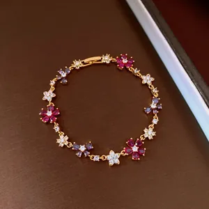 Detailed view of an elegant gold-plated bracelet with colorful zircon floral charms.