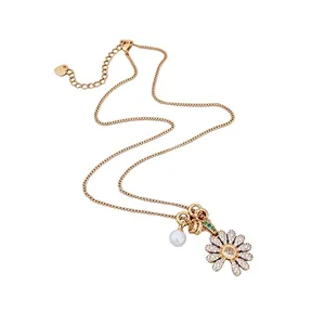 Élégant collier en or avec pendentif fleur en zircon scintillant et perle sur fond blanc