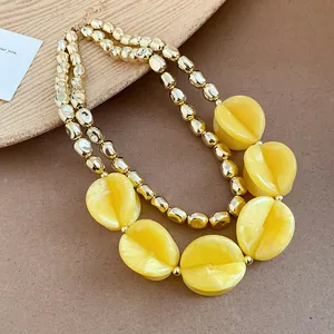 Detail showing texture of yellow acrylic discs and golden beads on double-layer necklace