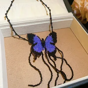 Intricate detail of a handmade purple and black beaded butterfly pendant with long tassels