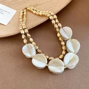 Detailed view of luxury double-layered necklace featuring gold beads and marbled acrylic discs