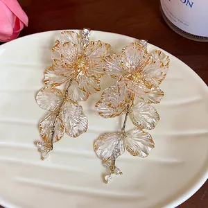 Detailansicht exquisiter Acryl-Blumenohrringe mit Strasssteinen auf einem weißen Teller
