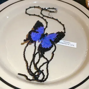 Detailed macro view of a handmade butterfly beaded necklace featuring purple and black beads