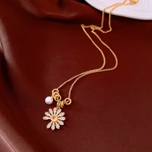 Vue détaillée d'un pendentif fleur en zircon et perle sur un collier de chaîne en or