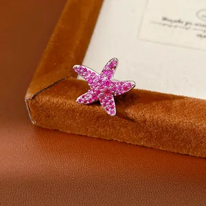 Gros plan d'un clip d'oreille étoile de mer en zircon rose avec pierres étincelantes et base