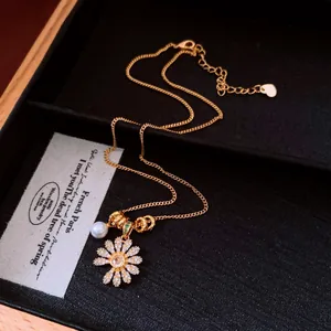 Détail d'un collier avec pendentif fleur vintage orné de zircons scintillants et d'une perle
