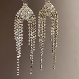 Close-up of sparkling rhinestone tassel drop earrings with a diamond-shaped stud design.