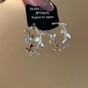Elegant silver C-shaped branch hoop earrings with a textured leaf design for women