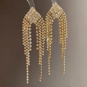 Close-up detail of elegant gold tassel earrings with sparkling crystal rhinestones for women