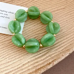 Detailed view of green marble-textured acrylic beaded bracelet with elegant gold spacers