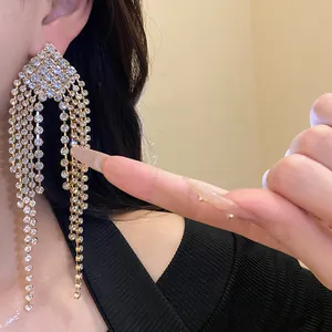 Close-up of elegant rhinestone diamond tassel earrings on a model