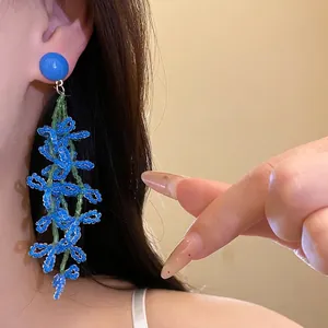 Elegant handmade long blue beaded flower tassel earrings with silver needle studs.