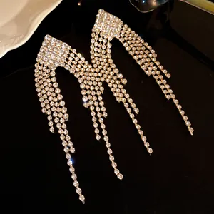 Close-up shot of exquisite silver needle rhinestone tassel earrings on black background