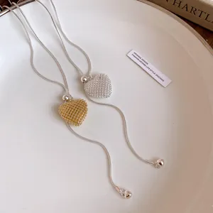 Close-up of heart-shaped woven pendant necklaces with adjustable pull-out chains