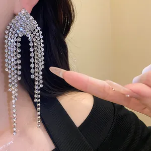 Close-up of sparkling rhinestone tassel drop earrings on model for elegant style