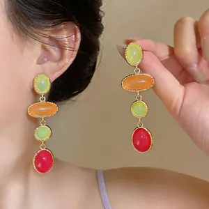 Close-up detail of colorful resin oval drop earrings in a vintage palace style