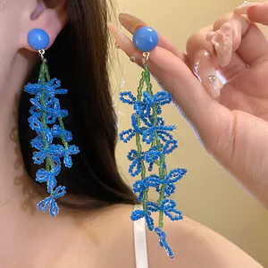 Detail shot of elegant blue beaded flower tassel earrings featuring glass beadwork.