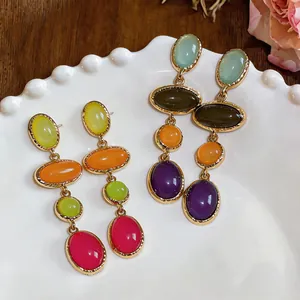 Detailed macro shot of vintage oval resin drop earrings with colorful stones