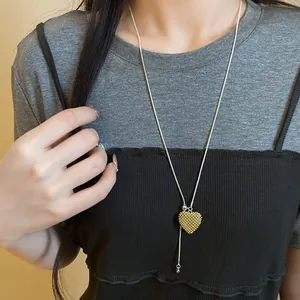 Detailed view of hollow heart pendant on an adjustable silver snake chain necklace