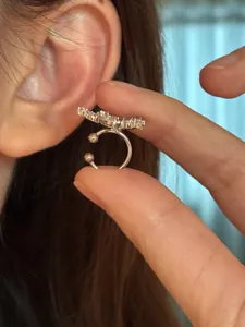 Close-up macro detail of a silver star ear cuff featuring sparkling cubic zircon settings