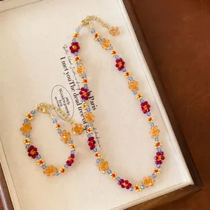 Close-up detail of a handmade colorful floral beaded necklace and bracelet jewelry set