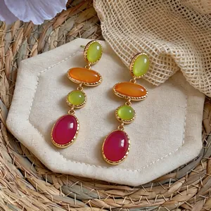 Close-up detail of vintage resin drop earrings with lime green and magenta oval stones