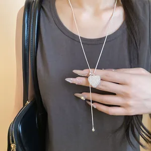 Close-up view of silver heart hollow pendant necklace with adjustable drawstring chain.