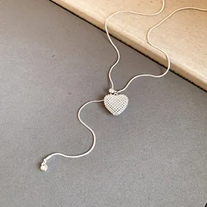 Detail view of silver hollow heart pendant necklace with adjustable snake chain.
