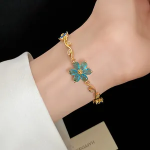 Vue détaillée d'un bracelet vintage plaqué or 18k avec des fleurs en zircon bleu.