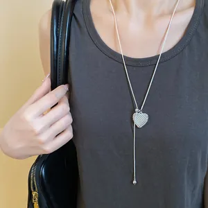 Elegant hollow heart pendant necklace on a model showing adjustable silver chain detail